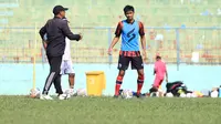 Jayus Hariono saat menerima instruksi dari asisten pelatih Arema I Putu Gede Swisantoso. (Iwan Setiawan/Bola.com)