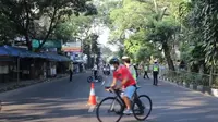 Petugas kepolisian menghalau pesepeda yang melintasi kawasan Sukajadi, Kota Bandung, Minggu (4/7/2021). Kegiatan penghalauan ini dilakukan seiring penerapan pemberlakuan pembatasan kegiatan masyarakat (PPKM) darurat. (Foto: Liputan6.com/Huyogo Simbolon)