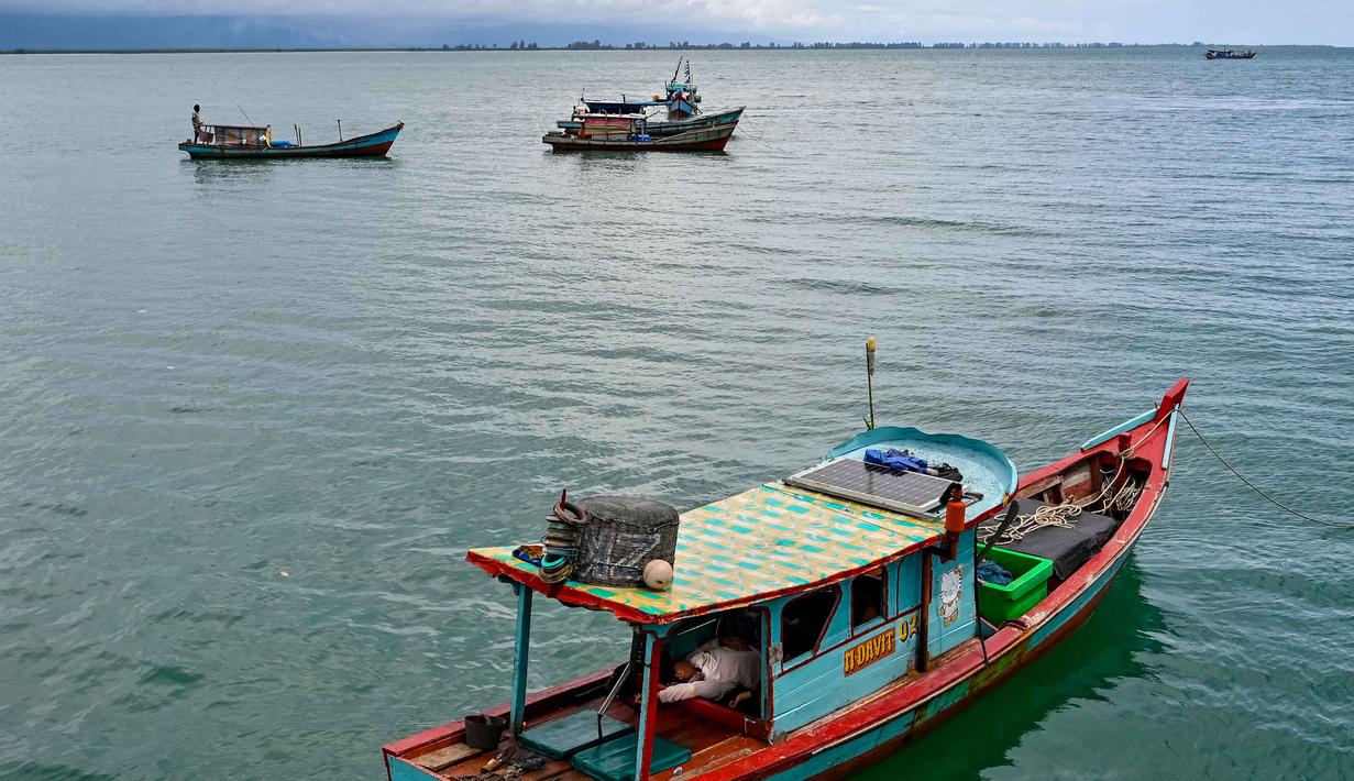 Perlu diketahui, keberadaan Pulau Panjang bersama dengan Pulau Lipan, Pulau Mangkir Gadang, dan Pulau Mangkir Ketek, pernah menjadi objek sengketa batas wilayah antara Provinsi Aceh dan Sumatera Utara. Tampak dalam foto, seorang nelayan beristirahat di perahunya yang berlabuh di lepas Pulau Panjang, yang pernah menjadi objek sengketa batas pulau antara Aceh dan Sumatra Utara, di Singkil, Provinsi Aceh Selatan, pada Rabu 12 November 2025. (CHAIDEER MAHYUDDIN/AFP)
