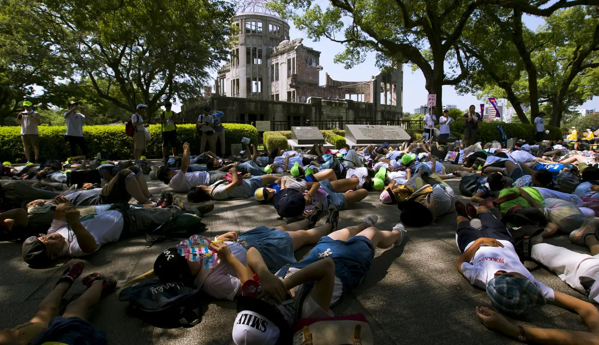 Sejumlah warga berbaring melakukan 'die-in' di depan Atomic Bomb Dome di Hiroshima, Jepang, Rabu  (5/8/2015). Jepang akan memperingati 70 tahun serangan terhadap Hiroshima, di mana AS menjatuhkan bom atom di 6 Agustus 1945. (REUTERS/Thomas Peter)