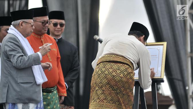 Calon wakil presiden nomor urut 02, Sandiaga Uno (kanan) menandatangani Deklarasi Kampanye Damai di Monas, Jakarta, Minggu (23/9). Deklarasi dihadiri pula oleh pimpinan partai pendukung kedua pasangan serta ribuan masyarakat. (Merdeka.com/Iqbal Nugroho)