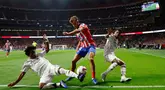Gelandang Atletico Madrid, Marcos Llorente (tengah) berebut bola dengan penyerang Real Madrid, Endrick dan Rodrygo selama pertandingan Liga Spanyol di stadion Metropolitano, Madrid, Minggu 29 September 2024 atau Senin (30/9/2024) dini hari WIB. (OSCAR DEL POZO/AFP)