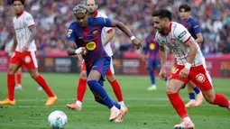Pemain Barcelona, Lamine Yamal, berusaha melewati pemain Girona pada laga pekan ke-9 La Liga 2025/2026 di Stadion Olimpic Lluis Companys, Sabtu (18/10) malam WIB. (AP Photo/Joan Monfort)