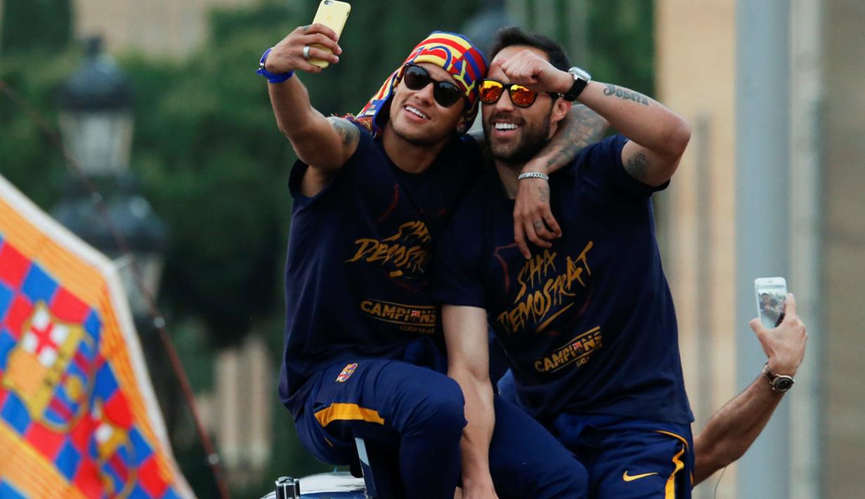 Neymar dan Claudio Bravo ber-selfie ria di atas bus saat pawai tim Barcelona untuk merayakan gelar La Liga ke-24, Minggu (15/5/2016). (AFP/Pau Barrena)