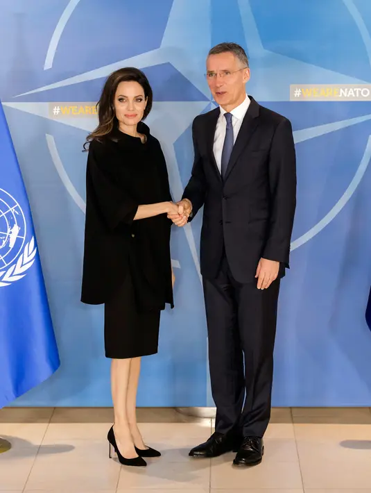 Aktris dan Duta UNHCR, Angelina Jolie bersalaman dengan Sekretaris Jenderal NATO Jens Stoltenberg usai menggelar konferensi pers di Markas Besar NATO di Brussels, Belgia (31/1). (AP Photo/Geert Vanden Wijngaert)