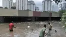 Petugas Pusat Pengelolaan Kompleks (PPK) Kemayoran membersihkan sampah yang muncul akibat banjir di Underpass Kemayoran, Jakarta, Minggu (2/2/2020). Selain melumpuhkan akses, banjir setinggi hingga 5 meter tersebut menyebabkan sampah memenuhi Underpass Kemayoran. (merdeka.com/Iqbal S. Nugroho)