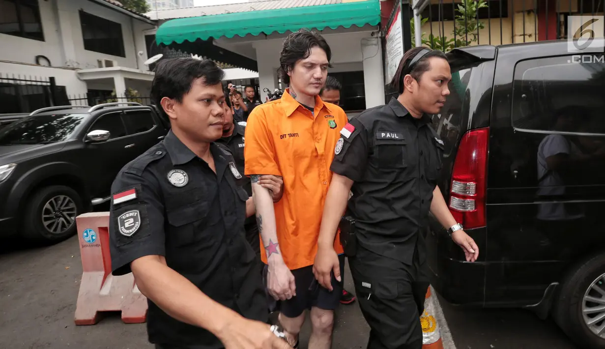 Anak musisi Ahmad Albar, Ozzy Albar dibawa petugas kepolisian seusai rilis kasus Narkoba di Polda Metro Jaya, Jakarta, Kamis (13/9). Ozzy ditangkap di sebuah ATM di Jalan Wolter Monginsidi dengan barang bukti ganja 2,66 gram. (Liputan6.com/Faizal Fanani)