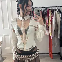 Ia memakai blus tipis yang memperlihatkan bra hitamnya, dipadukan dengan celana terawang yang memperlihatkan underwear, ditambah stoking orange dan garter. [@jennierubyjane].