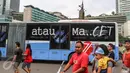Sebuah bus TransJakarta koridor 1 dengan stiker bertuliskan Merdeka atau Macet melintas ketika masyarakat Jakarta tengah berolahraga saat Car Free Day (CFD) di kawasan Bundaran HI, Jakarta, (14/08). (Liputan6.com/Fery Pradolo).