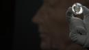 Seorang staf dari Royal Mint mengangkat koin lima pound bergambar Raja Charles III, yang akan menjadi salah satu koin pertama yang menyandang kepala raja baru, selama pratinjau pers di London, Kamis, 29 September 2022.   Koin bergambar Raja Charles III terlihat pada pecahan 50 pence, yang akan mulai beredar dalam beberapa bulan mendatang. (AP Photo/Alastair Grant)