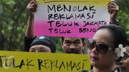 Sebuah poster penolakan reklamasi diperlihatkan salah satu massa saat unjuk rasa di depan kantor Kemenko Maritim, Jakarta, Jumat (16/9). Mereka mendesak Pemerintah menghentikan proyek reklamasi Teluk Jakarta dan Teluk Benoa Bali (Liputan6.com/Johan Tallo)