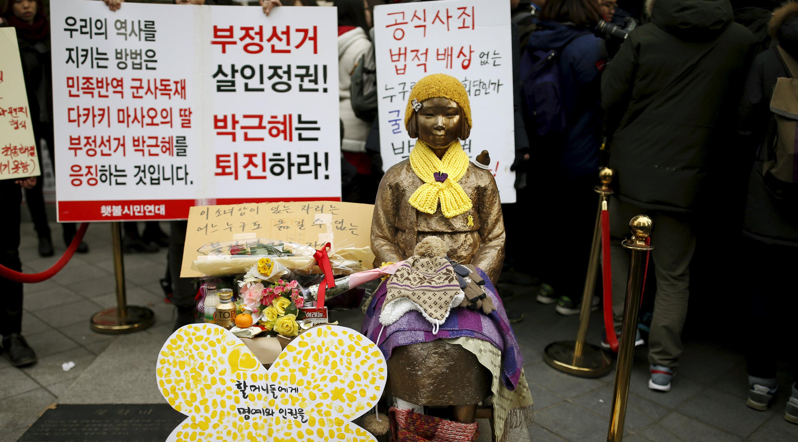 Wanita berdandan seperti patung untuk mewakili korban seksual militer Jepang pada Perang Dunia II di depan Kedutaan Besar Jepang, Seoul, Korea Selatan, (30/12). Mereka melakukan aksi Anti - Jepang selama beberapa pekan ini. ( REUTERS/Kim Hong - Ji)