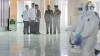 Presiden Joko Widodo atau Jokowi didampingi sejumlah menteri menyaksikan petugas menyemprotkan cairan disinfektan di Masjid Istiqlal, Jakarta, Jumat (13/3/2020). Proses sterilisasi dilakukan dalam rangka mencegah penularan virus corona Covid-19. (Liputan6.com/Faizal Fanani)