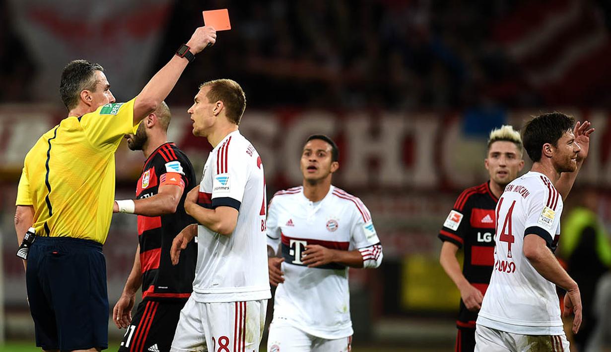 Wasit Knut Kircher, memberikan kartu merah kepada gelandang Bayern Munchen, Xabi Alonso saat laga melawan Leverkusen. Kini Munchen unggul delapan poin dari Dortmund yang berada pada posisi kedua. (AFP/Patrik Stollarz)