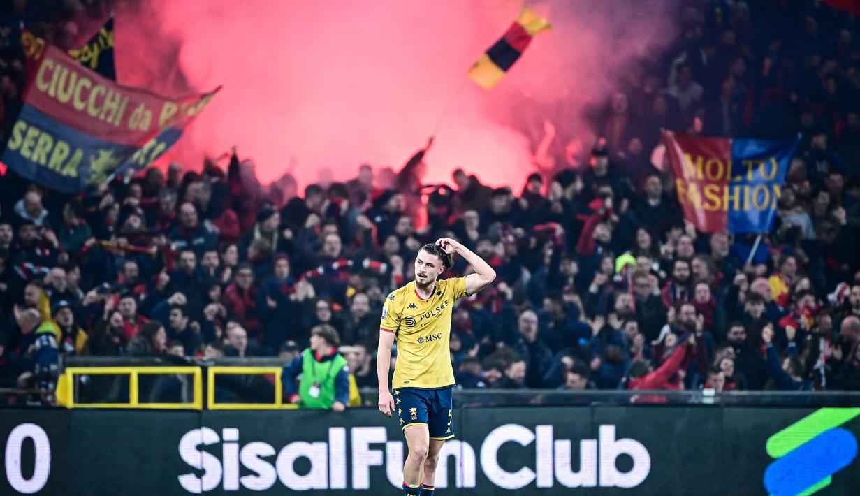 Suporter Genoa menyalakan suar untuk merayakan gol penyeimbang 1-1 yang dicetak oleh Radu Dragusin pada laga lanjutan Liga Italia 2023/2024 melawan Inter Milan di Stadion Luigi Ferraris, Genoa, Italia, Sabtu (30/12/2023) dini hari WIB. (AFP/Piero Cruciatti)
