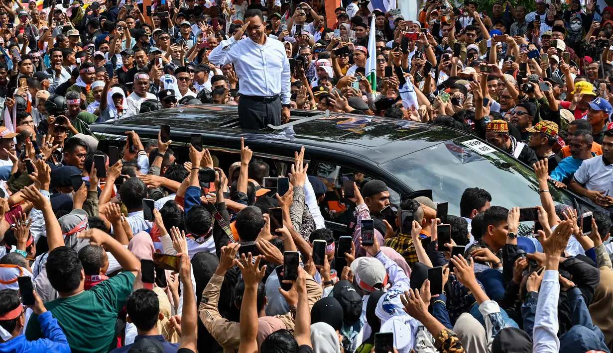 Calon Presiden nomor urut 1, Anies Baswedan (berbaju putih) menyapa para pendukungnya saat kampanye pemilu di Banda Aceh pada 27 Januari 2024. (CHAIDEER MAHYUDDIN/AFP)