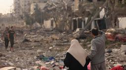 Warga Palestina memeriksa kehancuran besar-besaran akibat serangan udara Israel di distrik al-Rimal, Kota Gaza, pada 10 Oktober 2023. (MAHMUD HAMS/AFP)