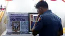 Seorang petugas kepolisian berdoa di depan jasad Rancel Cruz yang mati di tembak pecandu narkoba di Manila, Filipina, (19/10). Langkah tegas pemerintah Filipina membuat para pengguna narkoba membalas menembak petugas. (REUTERS/Erik De Castro)