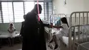 Seorang cosplayer berpakaian Darth Vader berbincang dengan seorang pasien saat acara amal oleh El Salvador Star Wars fan club di Rumah Sakit Benjamin Bloom Anak Nasional di San Salvador, El Salvador (14/12). (REUTERS/Jose Cabezas)