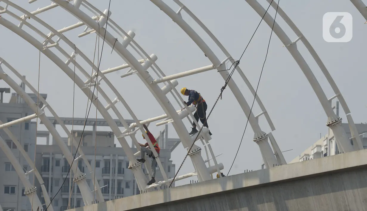 Pekerja menyelesaikan proyek pembangunan stasiun LRT Cawang-Gatot Soebroto, Jakarta, Jumat (26/6/2020). PT Adhi Karya (Persero) Tbk mencatat progres pembangunan jalur kereta api ringan atau light rail transit (LRT) Jabodebek tahap I telah mencapai 71,2% hingga 22 Mei 2020. (merdeka.com/Imam Buuhori)