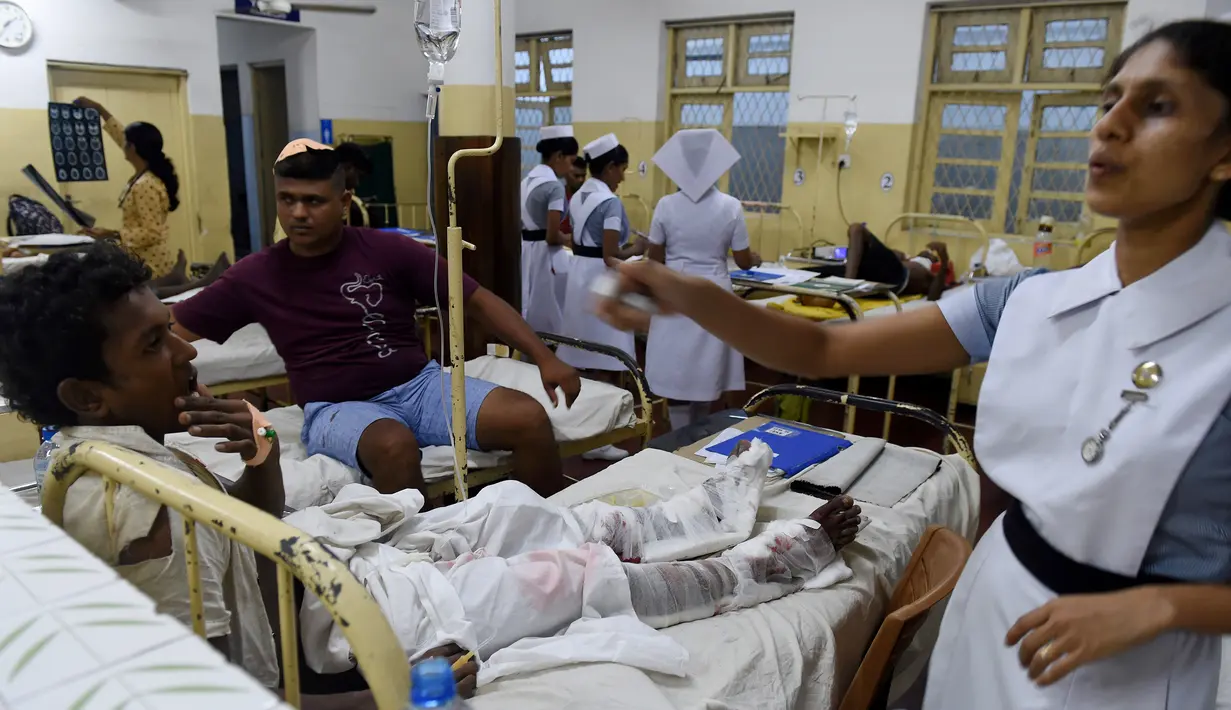 Sejumlah orang yang berhasil diselamatkan dari reruntuhan bangunan yang roboh di Kolombo, Sri Lanka, Kamis (18/5). Sedikitnya 20 pekerja berhasil diselamatkan dan puluhan lainnya masih dalam tahap pencarian. (AFP/Ishara S. KODIKARA)
