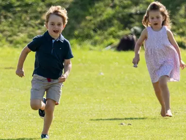 Pangeran George dan Putri Charlotte berlarian di atas rumput saat menghadiri acara amal Maserati Royal Charity Polo Trophy untuk mendukung sang ayah, Pangeran William yang bertanding di Beaufort Polo Club, Gloucestershire, Minggu (10/6). (AP Photo)