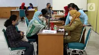 Petugas kesehatan mendata warga yang menjalani vaksinasi booster kedua atau dosis keempat di kawasan Kantor Wali Kota Jakarta Timur, Jakarta, Selasa (24/1/2023). Aturan vaksinasi booster kedua diumumkan Kementerian Kesehatan (Kemenkes) melalui Surat Edaran (SE) Nomor HK.02.02/C/380/2023 tentang Vaksinasi COVID-19 Dosis Booster Ke-2 Bagi Kelompok Masyarakat Umum yang diteken oleh Direktur Jenderal Pencegahan dan Pengendalian Penyakit (Dirjen P2P) Maxi Rein Rondonuwu pada 20 Januari 2023. (Liputan6.com/Johan Tallo)