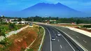 Kendaraan melintasi tol dengan latar belakang Gunung Salak saat Tol Fungsional Bocimi seksi 1 Ciawi-Cigombong dibuka menuju arah Ciawi di kawasan Ciawi Bogor (20/6). (Merdeka.com/ Arie Basuki)