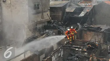 Petugas pemadam kebakaran saat mengevakuasi kebakaran yang terjadi di Jalan Kramat Pulo Dalam RT 03 RW 08, Senen, Jakarta, Selasa (3/11/2015). Sekitar 10 rumah hangus akibat kebakaran yang terjadi. (Liputan6.com/Gempur M Surya)