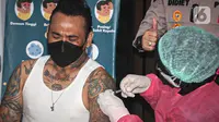 Musikus I Gede Ari Astina alias Jerinx menerima suntikan vaksin COVID-19 di Biddokkes Polda Metro Jakarta, Sabtu (15/8/2021). Jerinx mengaku telah berkonsultasi dan berdiskusi panjang dengan dokter ahli Virology sampai akhirnya memutuskan untuk menggunakan vaksin Sinovac (Liputan6.com/Faizal Fanani)