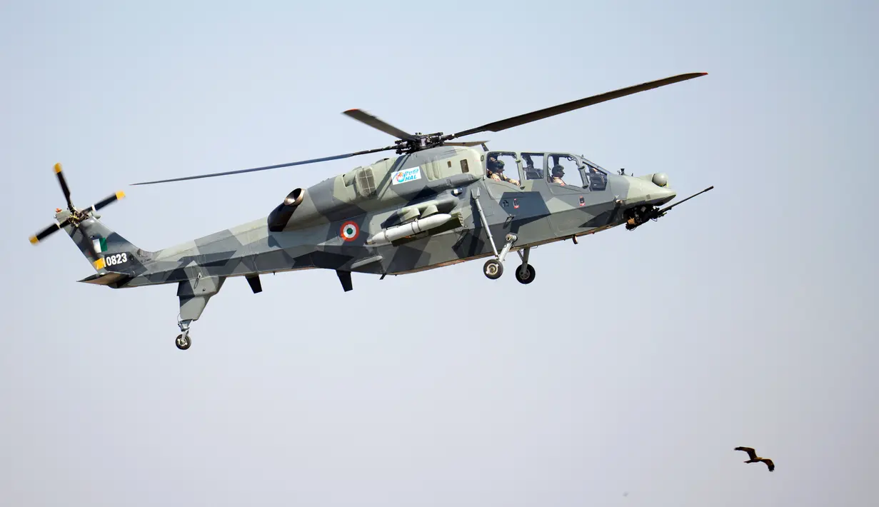 Helikopter tempur ringan India Prachand terbang di atas seekor burung saat peresmian Aero India 2023 di pangkalan udara Yelahanka, Bengaluru, India, Senin (13/2/2023). Aero India adalah acara dua tahunan dengan demonstrasi terbang oleh tim pengganti dan militer serta paviliun komersial tempat perusahaan penerbangan memamerkan produk dan teknologi mereka. (AP Photo/Aijaz Rahi)
