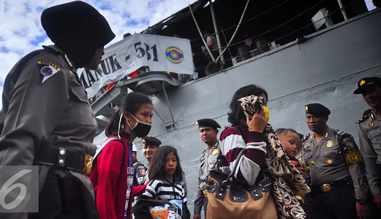 Mantan anggota Gafatar menutupi wajahnya saat tiba di Pelabuhan Tanjung Emas, Semarang , Senin (25/1). Warga eks Gafatar akan dibawa ke Embarkasi Donohudan, Solo. (Liputan6.com/Gholib)