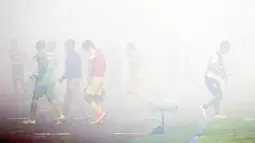 Para Pemain Madura United dan Persiba Balikpapan menuju ruang ganti ditengah kepulan asap flare pada Torabika SC 2016 di Stadion Gelora Bangkalan, Senin(13/6/2016).  (Bola.com/Nicklas Hanoatubun)