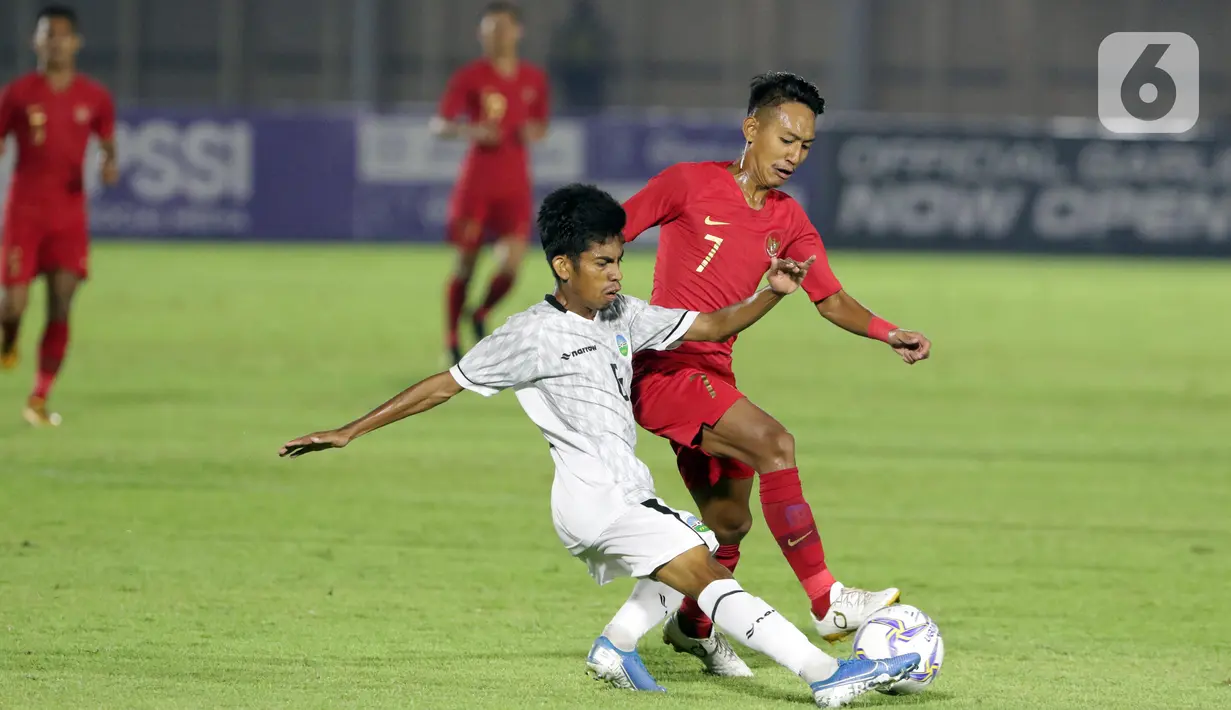 Pemain Timnas Indonesia U-19, Beckham Putra Nugraha (kanan) berebut bola dengan pemain Timor Leste pada laga kualifikasi Grup K Piala AFC U-19 2020 di Stadion Madya Gelora Bung Karno, Jakarta, Rabu (6/11/2019). Indonesia unggul 3-1. (Liputan6.com/Helmi Fithriansyah)