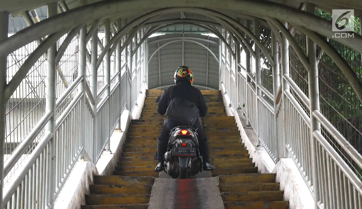 Pemotor melintasi jembatan penyeberangan orang (JPO) di kawasan Pasar Minggu, Jakarta, Rabu (24/4). Kurangnya kesadaran akan tertib berlalu lintas menyebabkan para pemotor itu nekat melintasi JPO, meskipun dapat merugikan hak pejalan kaki. (Liputan6.com/Immanuel Antonius)