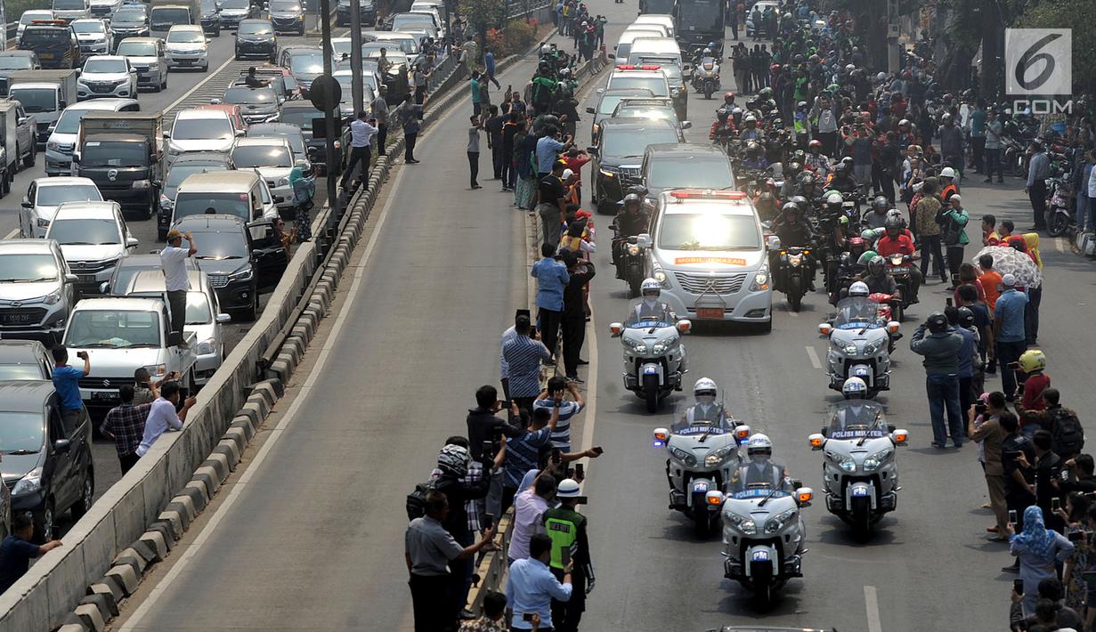Warga memberikan penghormatan terkahir kepada almarhum Presiden ke-3 RI, BJ Habibie saat iring-iringan mobil jenazah melintasi Jalan Gatot Subroto menuju TMP Kalibata, Jakarta, Kamis (12/9/2019). BJ Habibie meninggal pada Rabu (11/9/2019) usai menjalani perawatan di RSPAD. (merdeka.com/Arie Basuki)