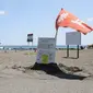 Bendera merah dikibarkan di tepi pantai di Hiratsuka, Prefektur Kanagawa, usai pemerintah mengumumkan 'peringatan gempa besar' di Jepang. (dok. STR / JIJI Press / AFP)