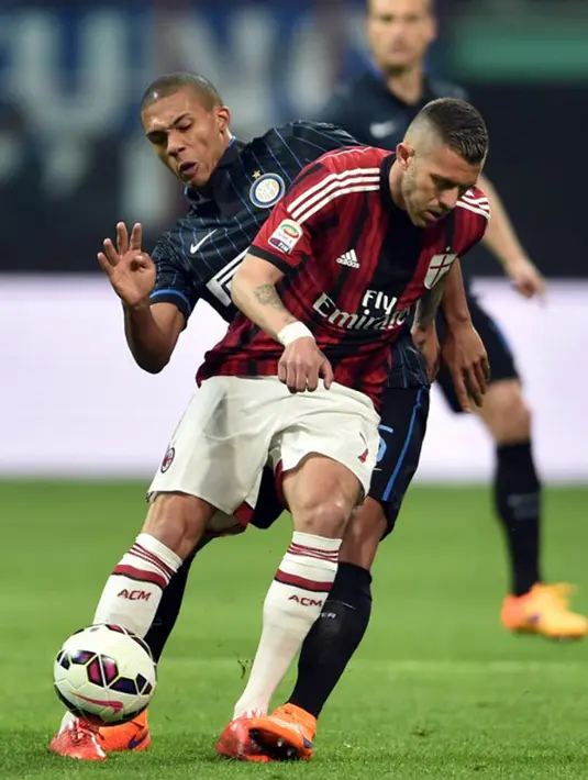 Penyerang AC Milan,  Jeremy Menez (depan) berusaha melewati bek Inter Milan Juan pada laga serie A di Stadio Giuseppe Meazza, Senin (20/4/2015). Inter Milan bermain imbang 0-0 dengan AC Milan. (AFP PHOTO/Giuseppe Cacace)