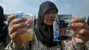 Seorang pelajar mengangkat gelasnya saat minum jamu bersama di Alun-Alun Satya Negara Sukoharjo, Jawa Tengah, Rabu (1/4/2015). Kegiatan tersebut dalam rangka pelestarian jamu ke masyarakat nasional maupun internasional. (Liputan6.com/Johan Tallo)