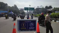 Sejumlah petugas di Simpang Gadog, Bogor, Jawa Barat memerhatikan pelat nomor kendaraan yang melintas menuju arah Puncak, Minggu (5/9/2021) pagi. (Liputan6.com/Achmad Sudarno)