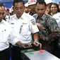 Menhub Budi Karya Sumadi menempelkan e-tiket pada reader gate sebelum naik KRL di Stasiun Juanda, Jakarta, Rabu (10/8). Menhub Budi meninjau proyek pembangunan kereta bandara Soekarno Hatta yang akan terintegrasi dari Jakarta. (Liputan6.com/Angga Yuniar)