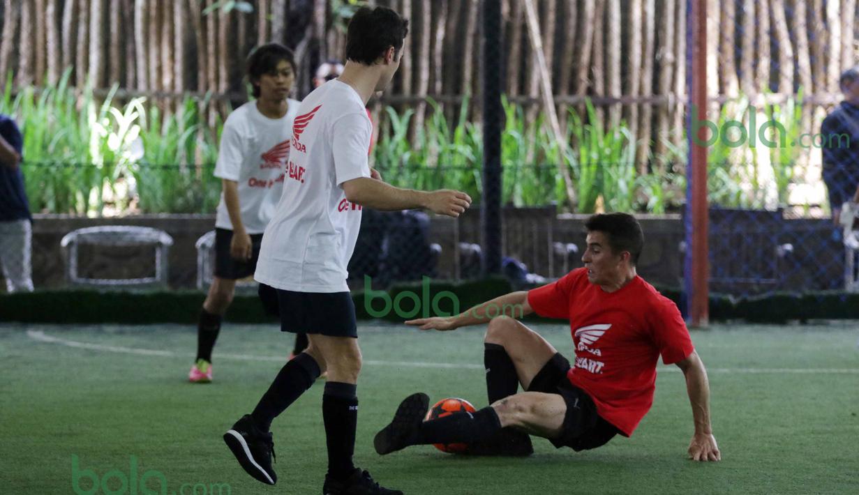 Marc Marquez (2kanan) terjatuh saat berebut bola dengan Dani Pedrosa  di Lapangan Futsal Kuningan Village, Jakarta, Sabtu (13/2/2016). (Bola.com/Nicklas Hanoatubun)