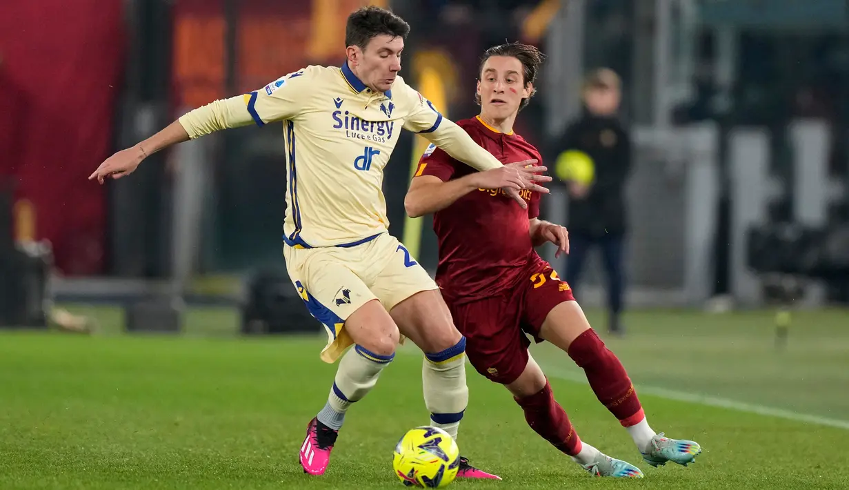 Pemain Verona Giangacomo Magnani (kiri) berebut bola dengan pemain AS Roma Edoardo Bove pada pertandingan sepak bola Liga Italia di Stadion Olimpiade Roma, Italia, 19 Februari 2023. AS Roma mengalahkan Verona dengan skor 1-0. (AP Photo/Andrew Medichini)