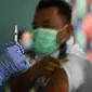 Seorang petugas kesehatan menyiapkan suntikan vaksinasi COVID-19 keempat atau booster kedua untuk petugas bandara di kantor otoritas Bandara Ngurah Rai, dekat Denpasar, Bali, Senin (30/1/2023). Para pekerja di bandara ini merupakan garda terdepan yang berinteraksi langsung dengan pelaku perjalanan luar negeri atau PPLN. (SONNY TUMBELAKA / AFP)