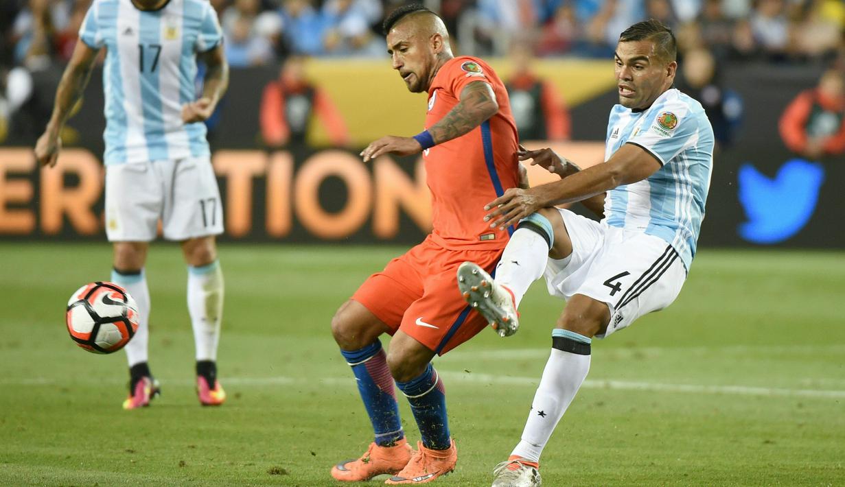 Gelandang Chile, Arturo Vidal (tengah) berusaha mengontrol bola dari kawalan bek Argentina, Gabriel Mercado pada Copa America Centenario 2016 di Levi's Stadium, California, AS (7/6). Argentina menang atas Chile dengan skor 2-1. (AFP/Mark Ralston)