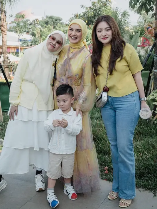 Nathalie Holscher mengenakan atasan warna kuning dipadukan celana denimnya. Dengan tas sling bag silvernya.   [@_irishbella_]