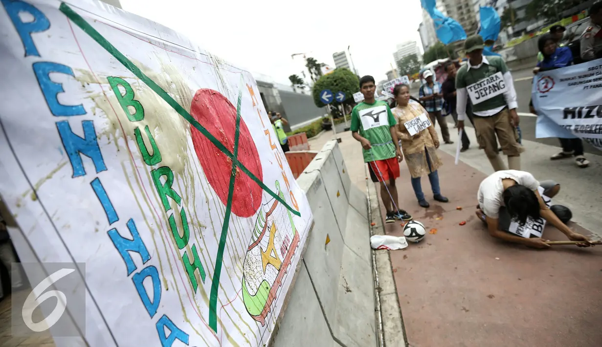 Massa melakukan aksi treatikal berunjuk rasa di depan Kedutaan Besar Jepang, Jakarta, Selasa (9/2). Mereka menuntut penyelesaian kasus PHK 1.300 buruh PT Panarub Dwikarya yang membuat sepatu Adidas dan Mizuno pada 2012 silam. (Liputan6.com/Faizal Fanani)