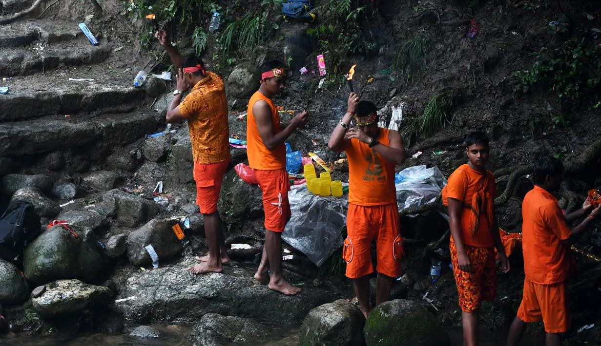 Umat hindu Nepal berdoa saat dalam perjalanan ke kuil Pashupatinath untuk melakukan perayaan Shravan di Sundarijal di pinggiran Kathmandu (7/8). (AFP Photo/Prakash Mathema)