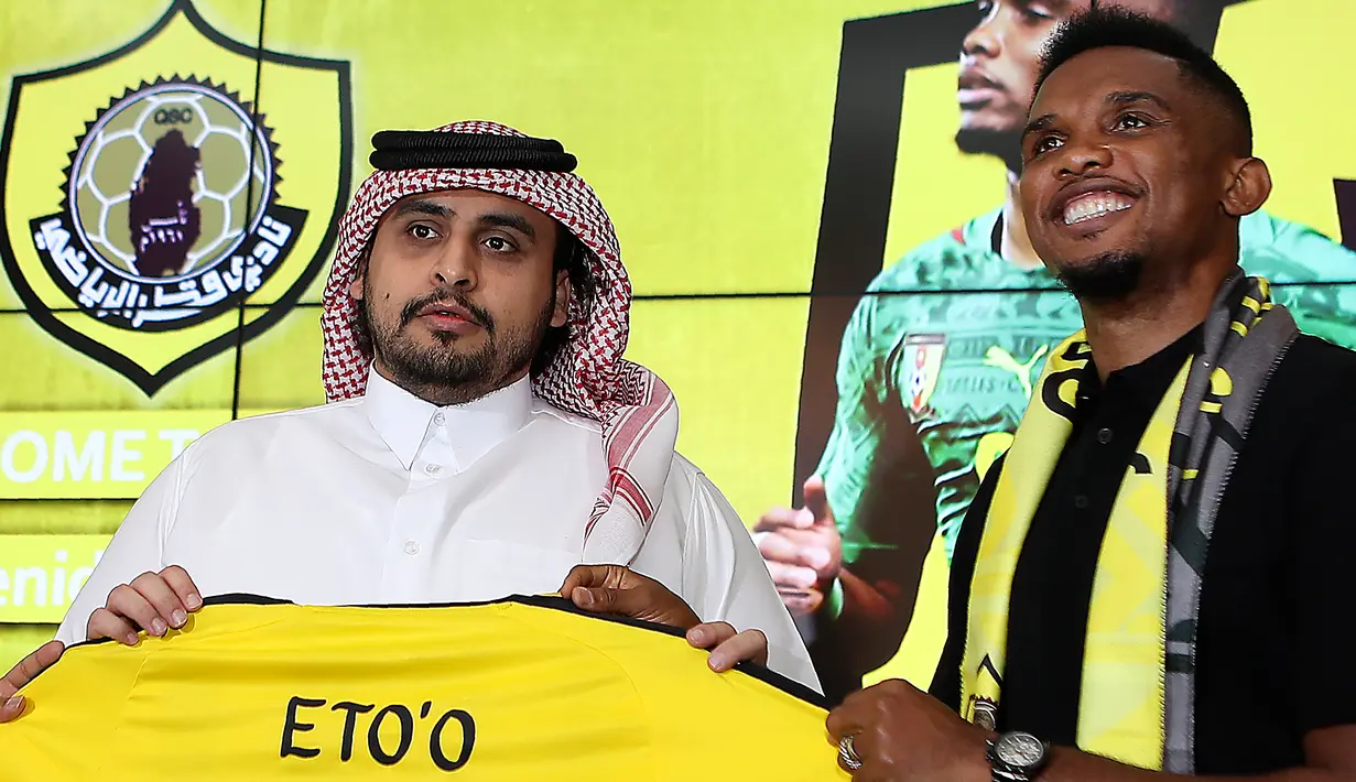 Penyerang asal Kamerun Samuel Eto'o berpose dengan jersey klub barunya  Qatar Sports Club selama presentasi dirinya di Doha, (14/8). Eks Striker Barcelona ini menandatangani kontrak selama satu tahun di klub tersebut. (AFP Photo/Karim Jaafar)