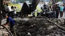 Pekerja dibantu alat berat membongkar saluran air yang akan diperbaiki di jalan Hayam Wuruk, Jakarta, Selasa (20/11). Perbaikan dan pelebaran saluran air ini untuk mengantisipasi terjadinya banjir di kawasan tersebut saat hujan. (Liputan6.com/Johan Tallo)